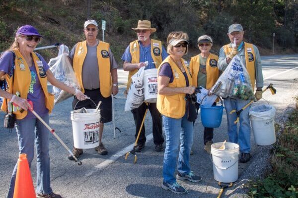 Volunteers smiling at Annual Yuba River Cleanup with trashpickers, buckets and bags